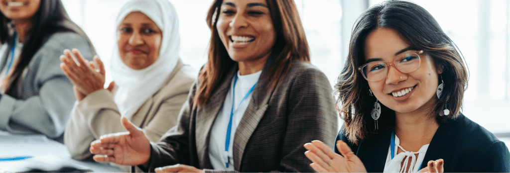 people in an office are smiling and clapping